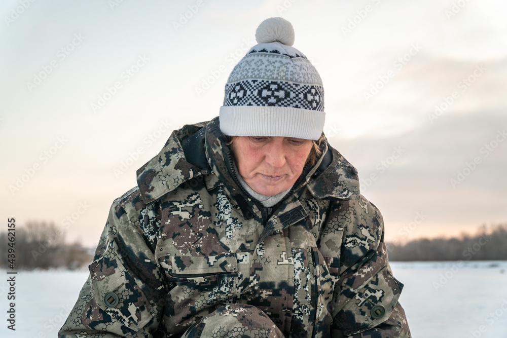 Portrait of a woman looking down wearing camouflage 