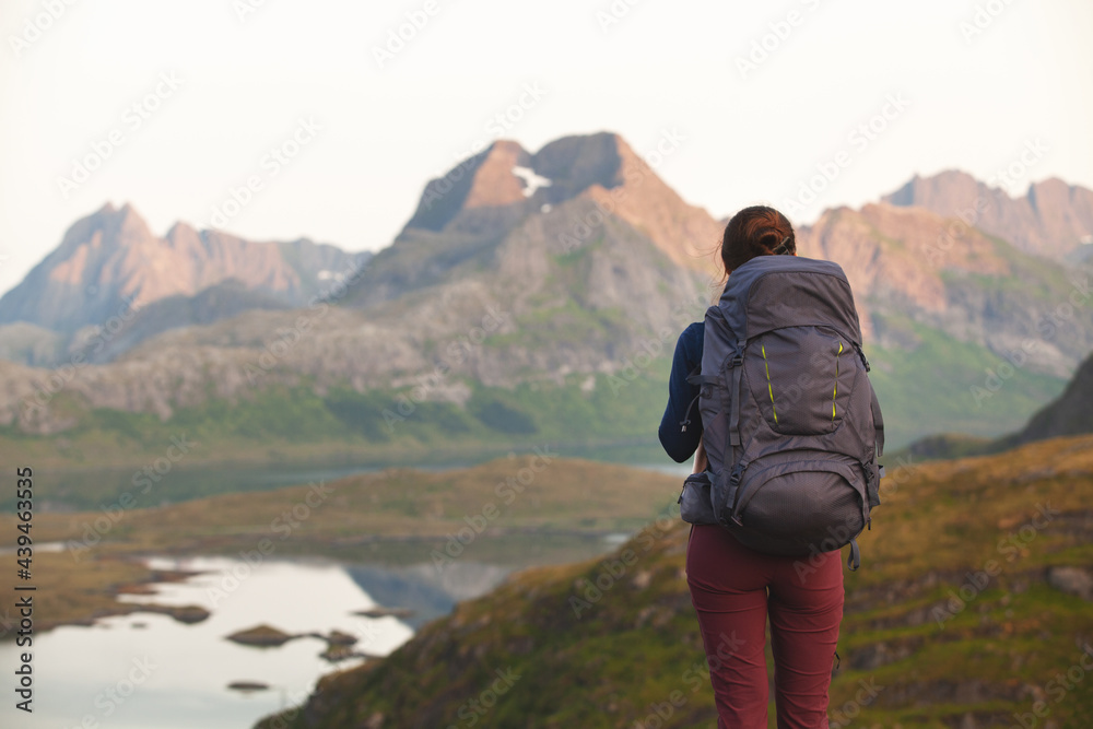 Man with a large backpack on a hike against the backdrop of the mountains