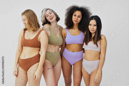 group of different women in lingerie hugging and smiling photo
