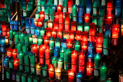 Arrangement of colorful lit candles in the dark