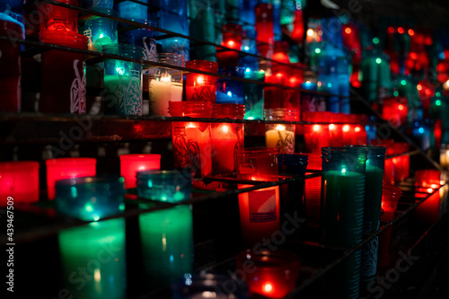 Arrangement of colorful lit candles in the dark photo