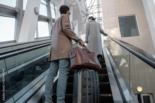 Young couple riding escalator in airport