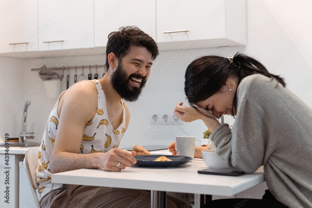 Happy couple laughing during breakfast Happy couple laughing during breakfast