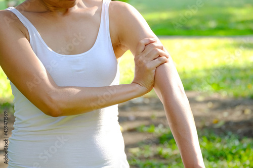 Arms Pain.  Woman Suffering From Painful Feeling In Arm Muscles.in the park. health concept photo