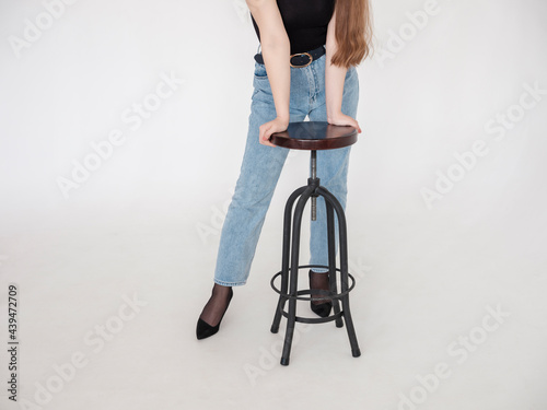 A young woman rests against a bar stool. photo