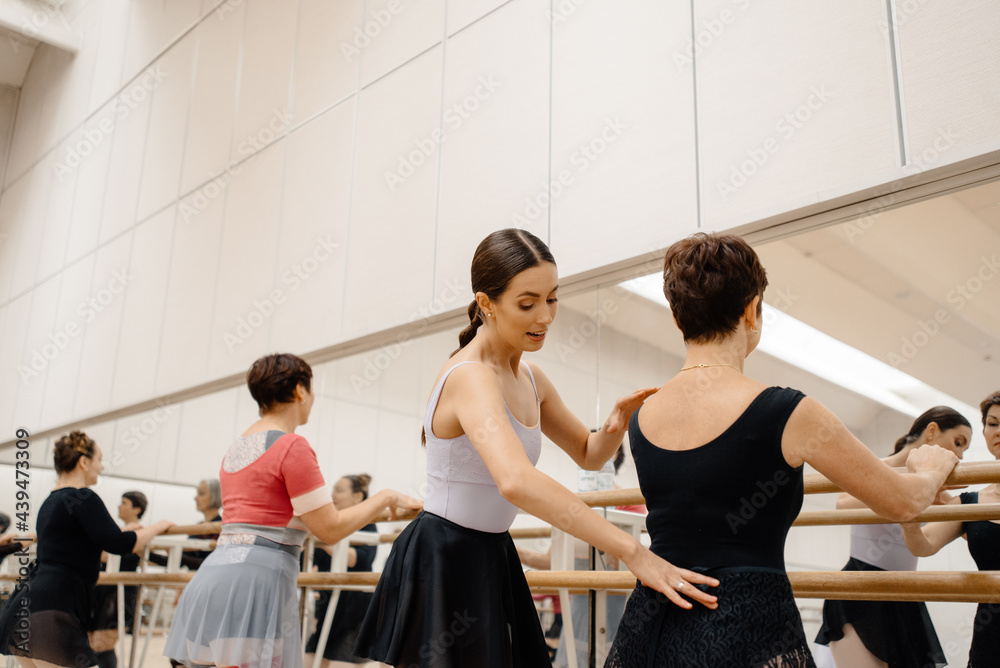 Trainer helping mature ballerina during class in studio
Trainer helping mature ballerina during class in studio