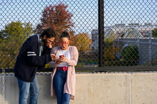 Couple looking at hilarious content on mobile phone 