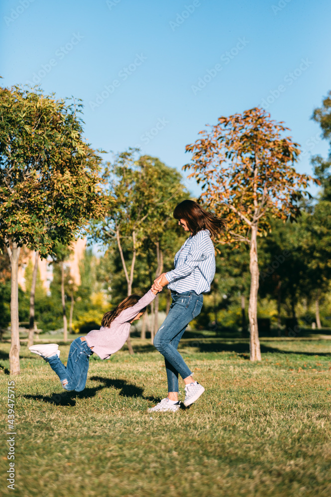 Delighted woman and girl having fun in park Delighted woman and girl having fun in park