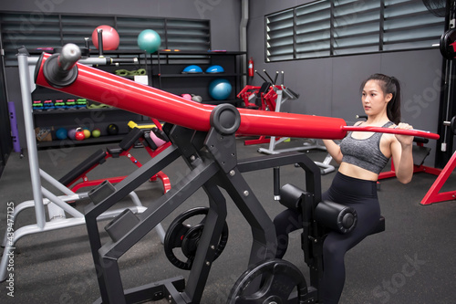 Asian woman doing upper body exercises with Lat pulldown machine in fitness © preebangsaen