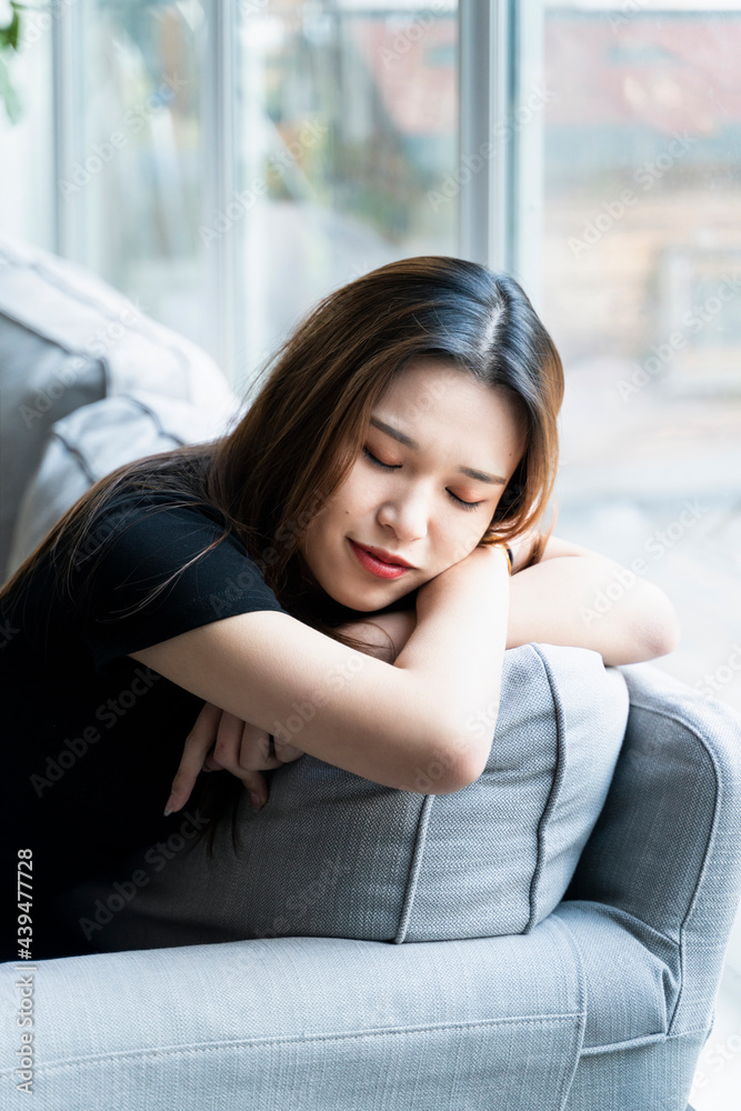 A woman is sleeping with a ray of sunlight on her face A woman is sleeping with a ray of sunlight on her face