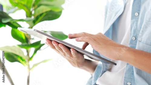 Close up of man hand using digital tablet for working at home, online study, telecommunication