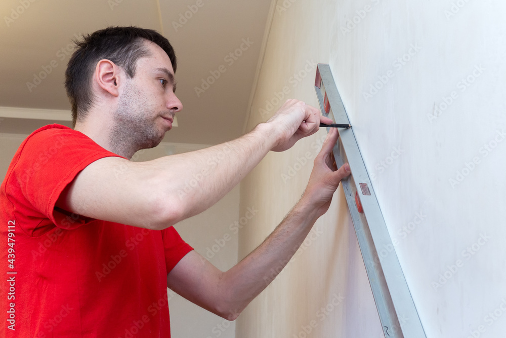 Man repair worker checking level of the wall with the bubble level tool. Renovation apartment concept