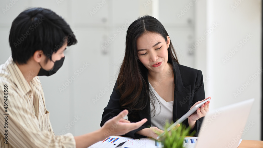 Obraz premium Two businesspeople working on their project together in office.
