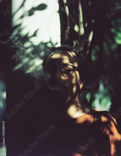 A man smoking in a tree shadow photo