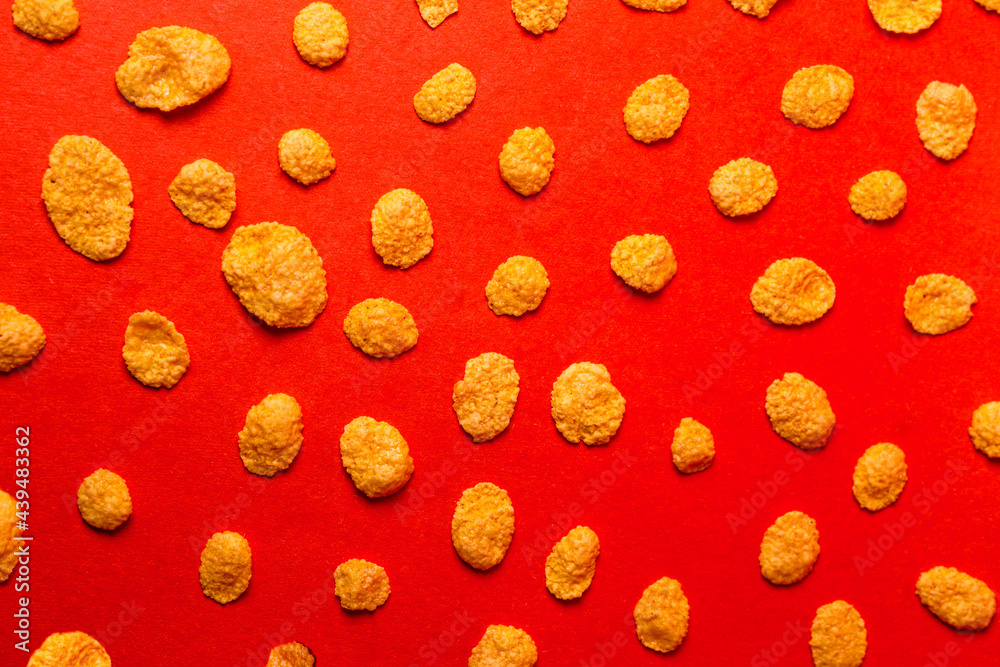 background of cornflakes on a red background. background of cornflakes on a red background.