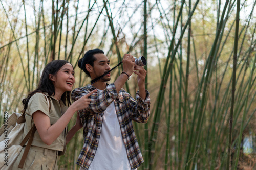 Male and female tourists are touring nature and taking pictures of the scenery. Couples go wild together on weekends. Nature tourism concept.