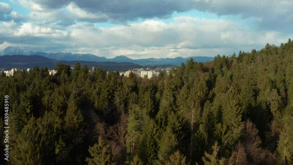 Breathtaking scenery of Ljubljana City, Slovenia on a cloudy day. Revealing shot from behind pine forest. Aerial Breathtaking scenery of Ljubljana City, Slovenia on a cloudy day. Revealing shot from behind pine forest. Aerial