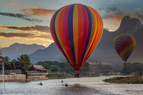 Nam Song river at sunset with hot air balloon in Vang Vieng, Laos, Beautifull landscape on the Nam Song River in Vang Vieng, Laos.