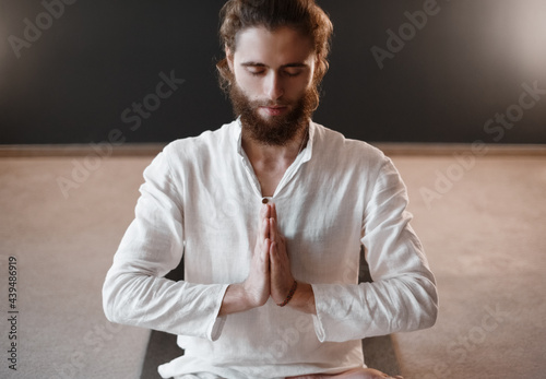 Calm male meditating in studio