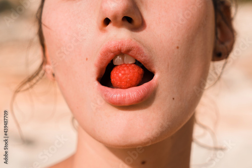 Sensual woman's mouth with raspberry photo