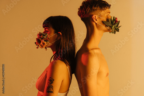 back to back couple wearing flower masks photo