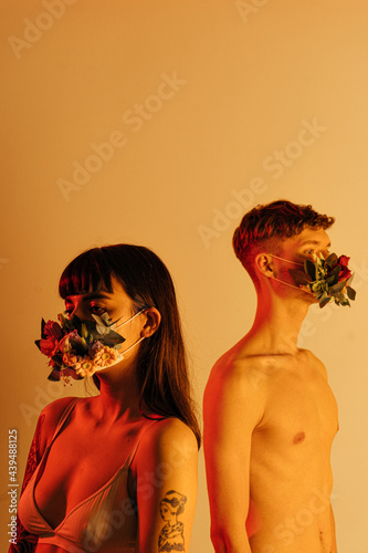 young couple in flower masks in the studio photo