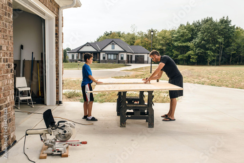 Dad working on a woodworking project with the help of his son. 