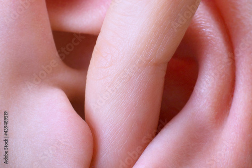 finger in ear closeup photo
