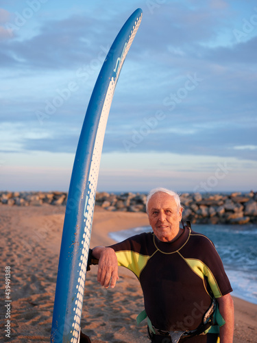 Aged man with windsurf table at the beach photo