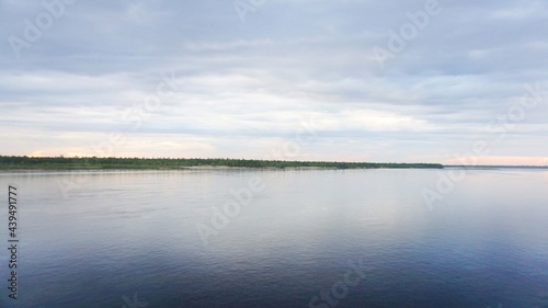 landscape gray blue sky clouds river sea in the distance on the horizon forest trees