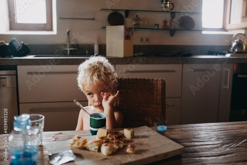Little boy still sleepy at the breakfast table