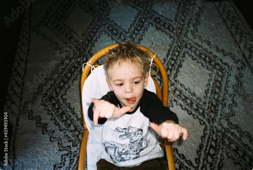 analog night shot of child sitting in a rattan rocking chair