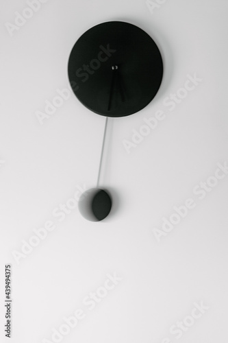 Black pendulum clock with slow shutter speed mouvement 