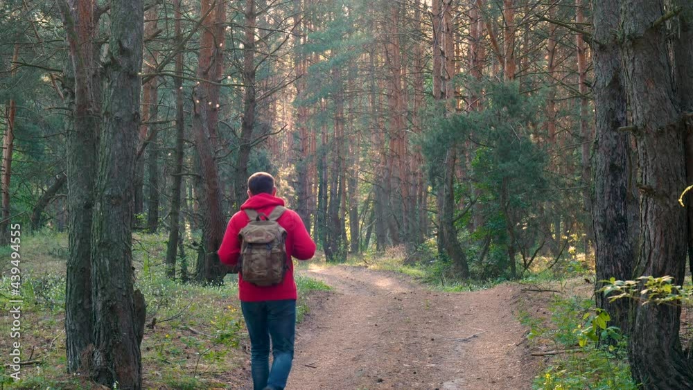 Tourist guy with backpack hiking on an adventure trip in natural landscape Tourist guy with backpack hiking on an adventure trip in natural landscape