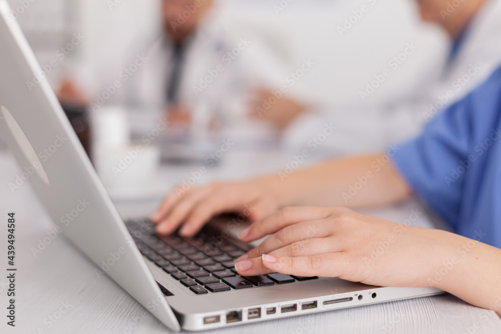 Close-up of therapist asisstant hands working at healthcare treatment typing sickness pill medication on laptop computer sitting at desk in meeting room. Physician nurse diagnosing patient disease Close-up of therapist asisstant hands working at healthcare treatment typing sickness pill medication on laptop computer sitting at desk in meeting room. Physician nurse diagnosing patient disease