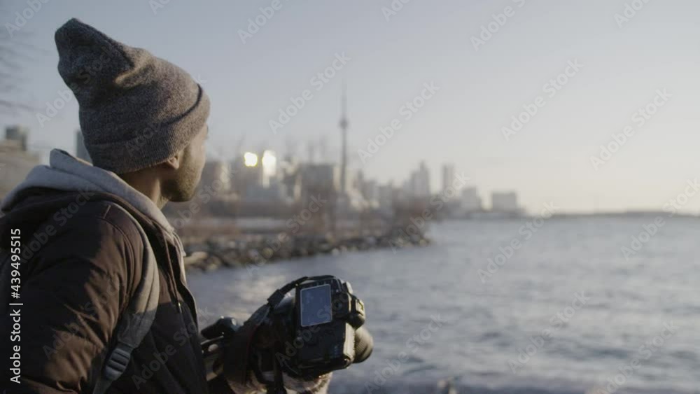 Photographer walking with Toronto skyline in background