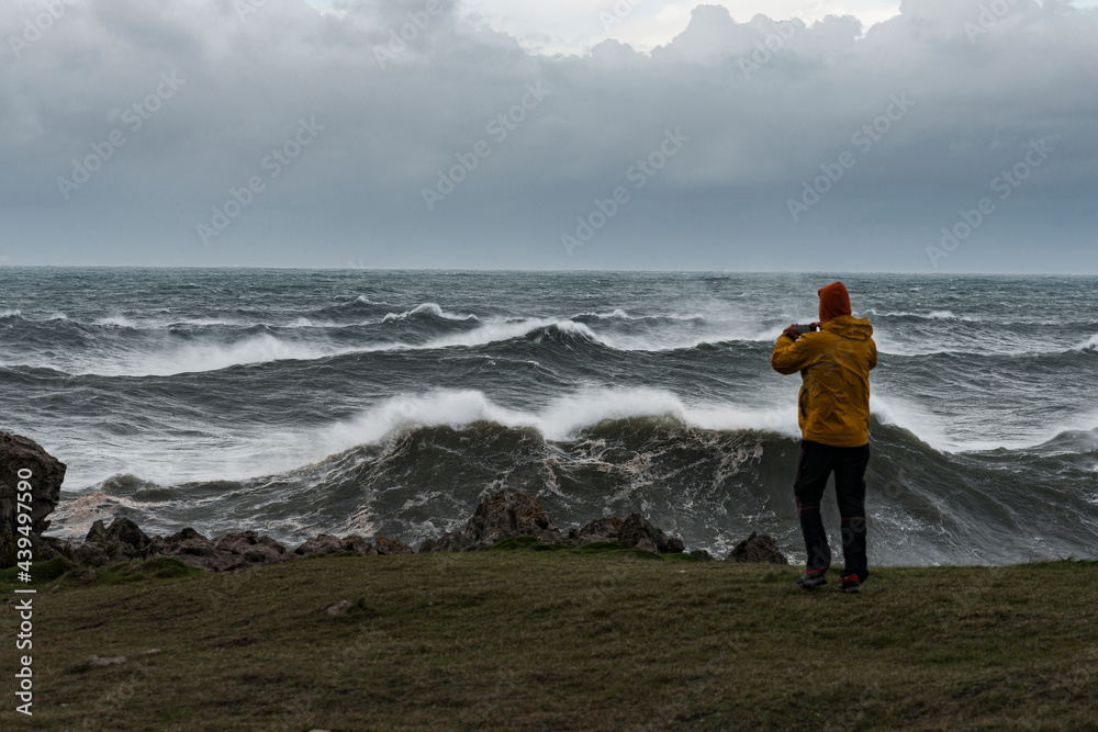 Courageous male taking photo of stormy waves Courageous male taking photo of stormy waves