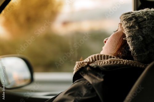 Young woman sleeping on copilot seat in van  photo