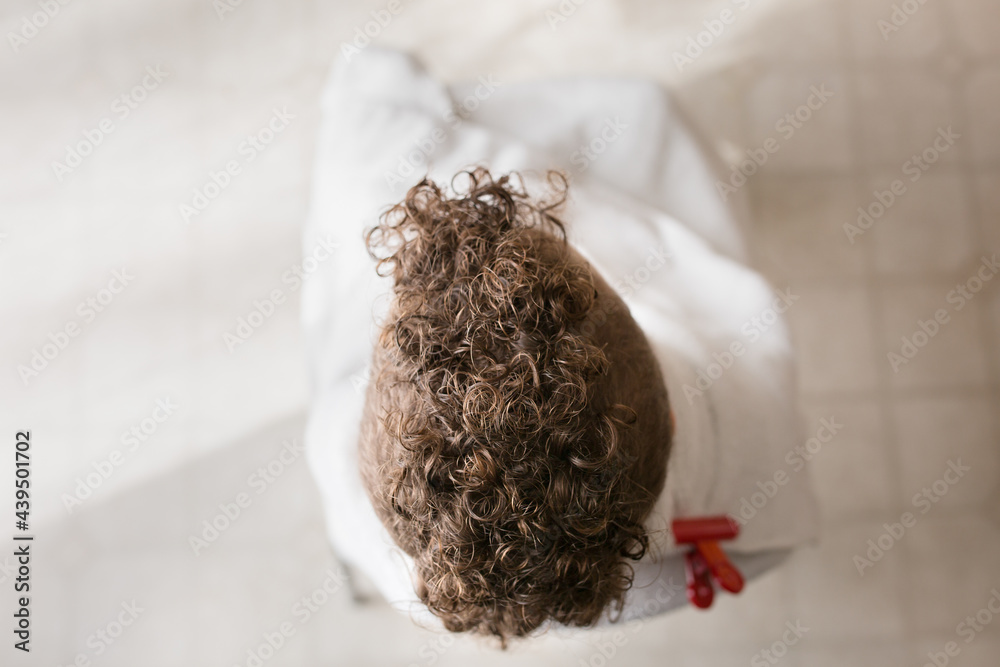 Child with curly mohawk sits wrapped in towel Child with curly mohawk sits wrapped in towel
