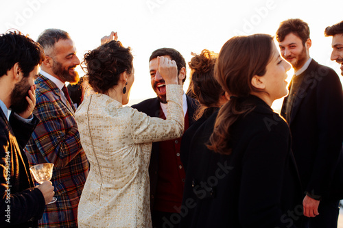 Unrecognizable happy stylish partners celebrating festive occasion in sunlight