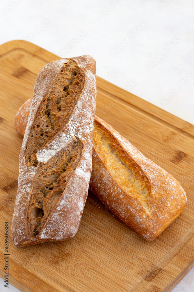 Hot bread fresh from the oven. Wheat bread on wooden background