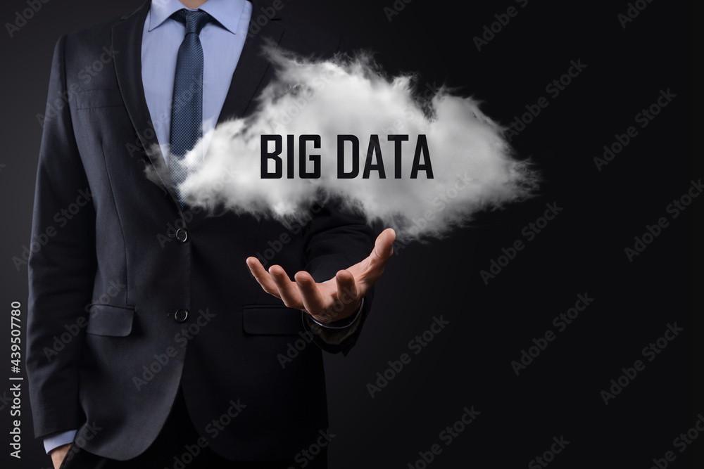 Hand showing a cloud with the words big data on dark background. Hand showing a cloud with the words big data on dark background.