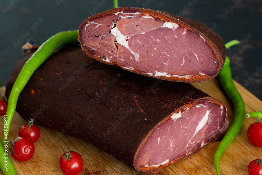 Turkish pastrami on a wooden serving plate. Pastrami is made from the