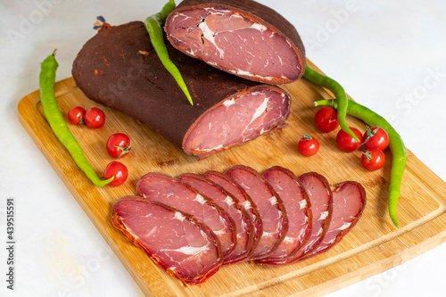 Turkish pastrami on a white background. Whole and sliced pastrami. pastrami is made from the ribeye and beef fillet parts of the cow. Local name pastırma