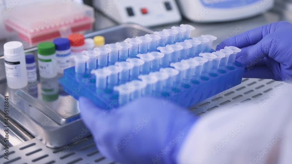 Hands of a laboratory assistant in medical gloves, works with Covid-19 analyzes in test tubes in a fume hood. Close-up side view and slider camera zoom. FullHD Slow Motion Hands of a laboratory assistant in medical gloves, works with Covid-19 analyzes in test tubes in a fume hood. Close-up side view and slider camera zoom. FullHD Slow Motion