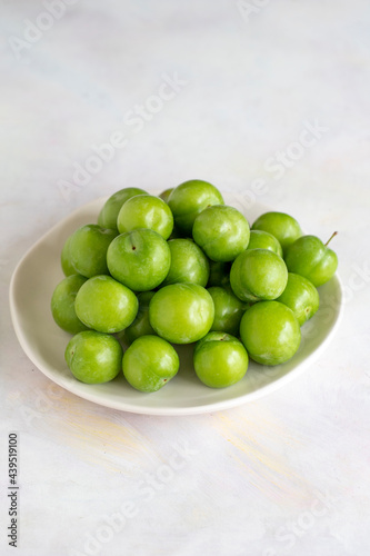 Green plum on a white background.