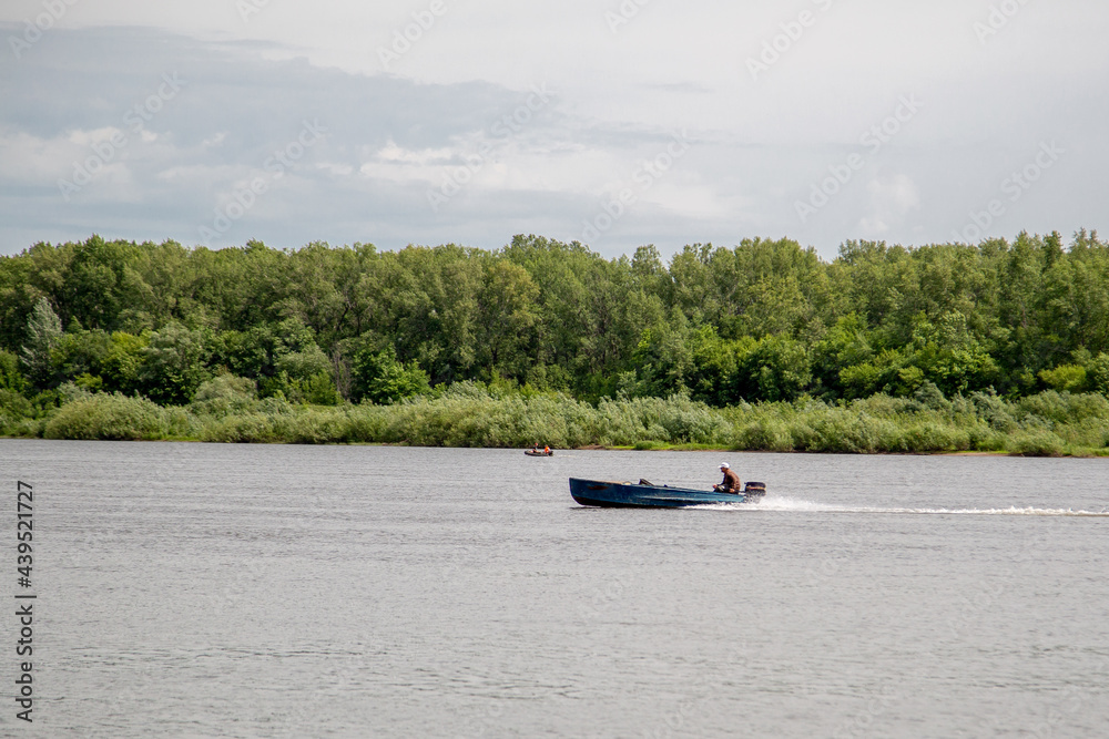Obraz premium the motor boat goes along the river