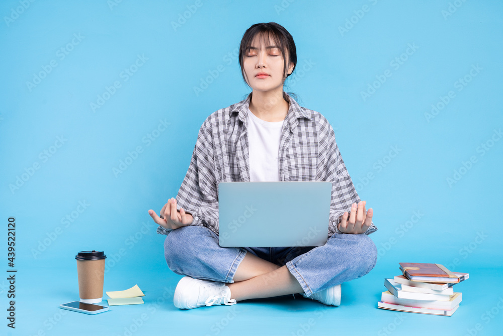Asian female student with playful expression on blue background Asian female student with playful expression on blue background