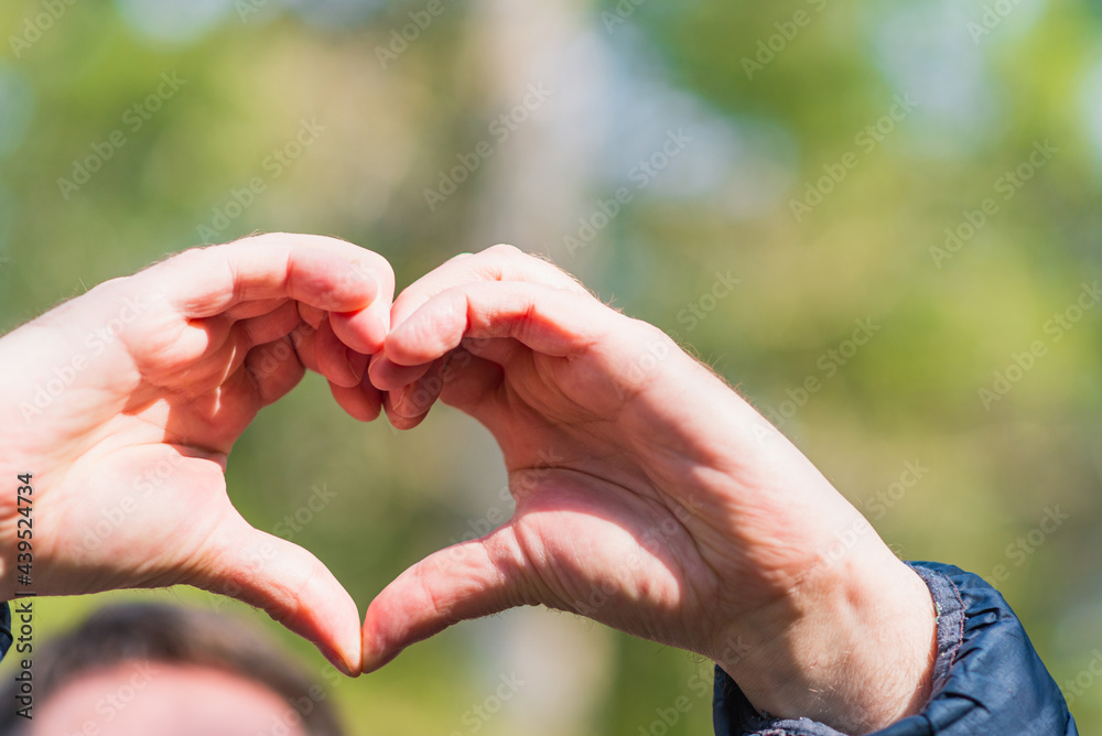 Heart with hands outdoors on sunny day at forest, closeup Heart with hands outdoors on sunny day at forest, closeup