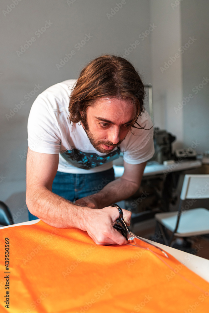 Textile designer using scissors to cut fabric Textile designer using scissors to cut fabric